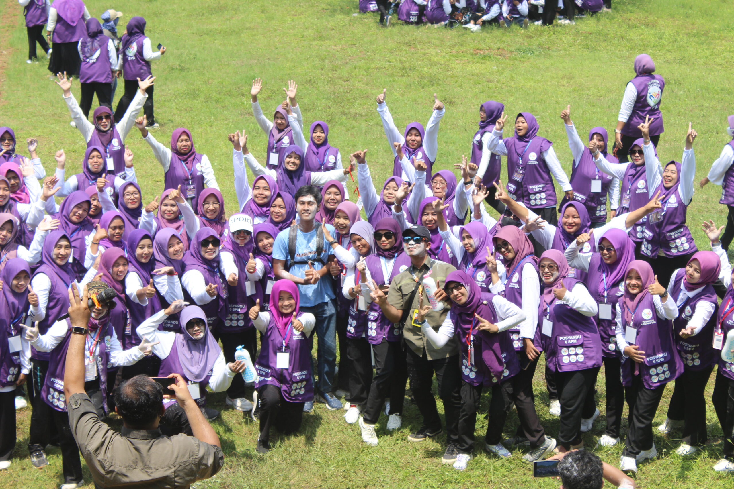 Peserta outbound perusahaan berfoto bersama usai kegiatan team building di lapangan terbuka