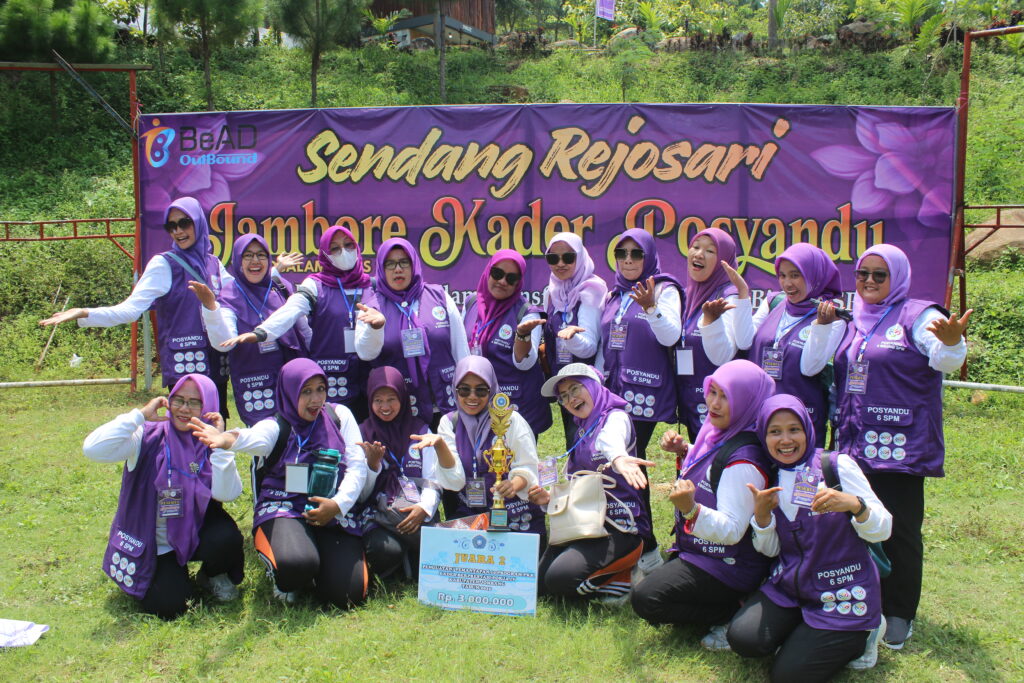 Suasana outbound perusahaan di area outdoor dengan peserta berfoto bersama setelah kegiatan