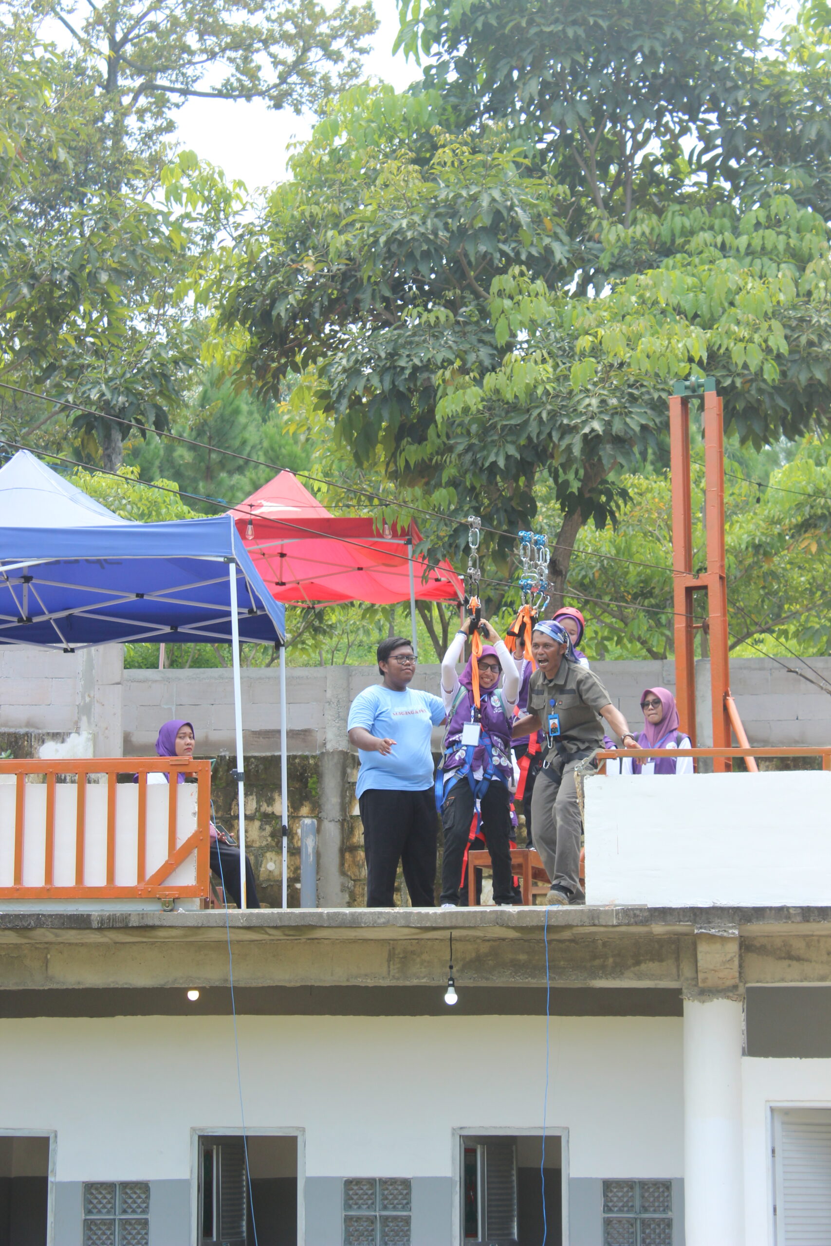 Peserta outbound perusahaan mengikuti simulasi problem solving di area outdoor dengan penuh fokus